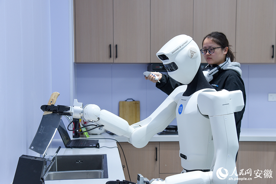 具身机器人正在训练师的操控下，反复训练动作。人民网记者 李希蒙摄